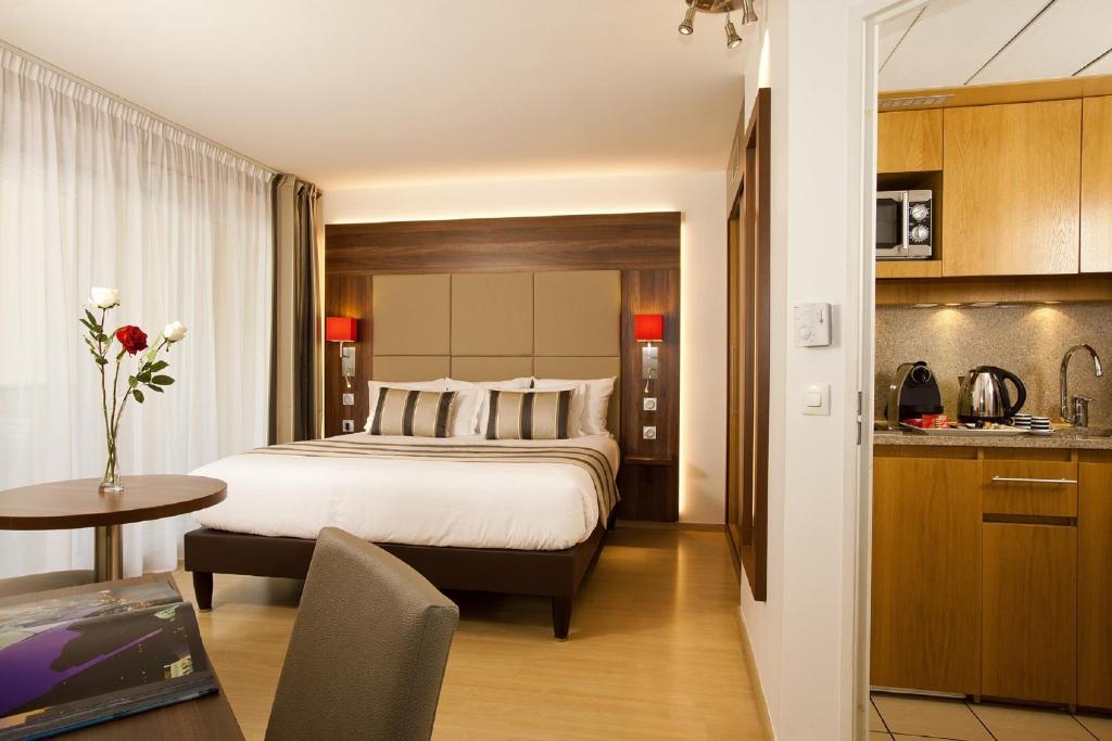 a hotel room with a bed and a kitchen at Residhome Paris-Massy in Massy