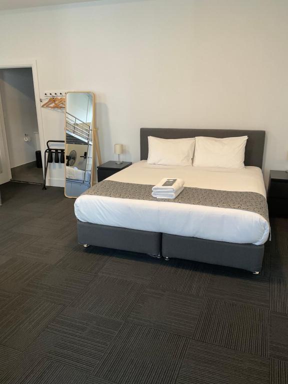 um quarto com uma cama grande e um espelho em Argyle Accommodation em Hobart