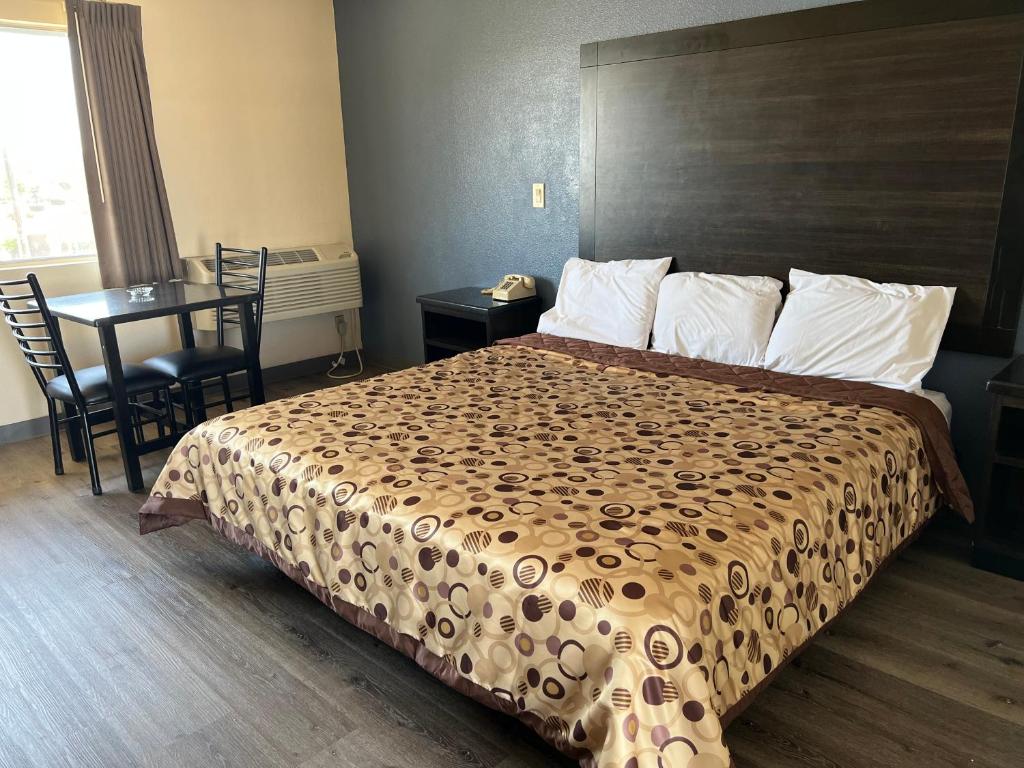 una habitación de hotel con una cama grande y una mesa en Economy Inn Fresno, en Fresno