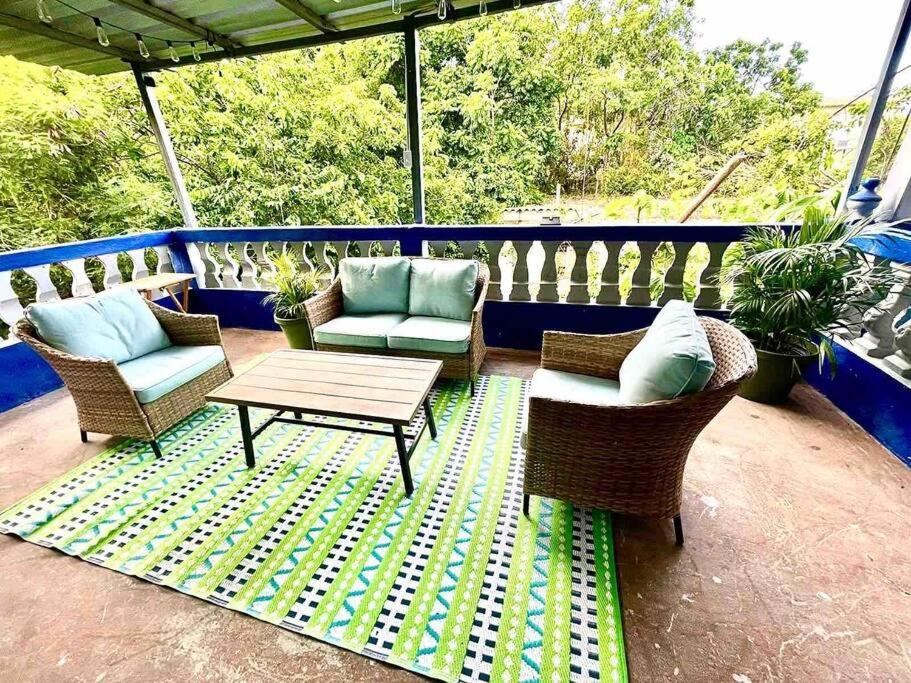 un patio con sillas y una mesa en una terraza en 2C - Couples Getaway-5 min to Crashboat Beach en Aguadilla