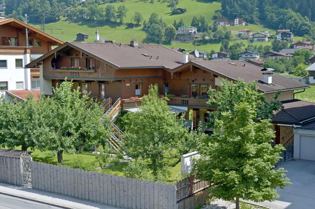 ein Haus in einem Dorf mit Bäumen und einem Zaun in der Unterkunft Appartement Elisabeth in Ramsau im Zillertal