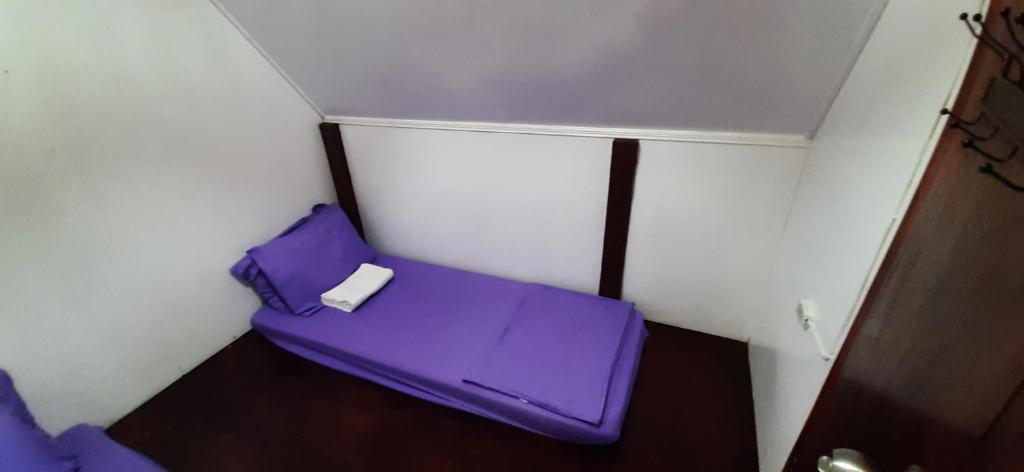 Piccola camera con letto viola in un angolo. di Dream Catcher Nipas Siargao a General Luna