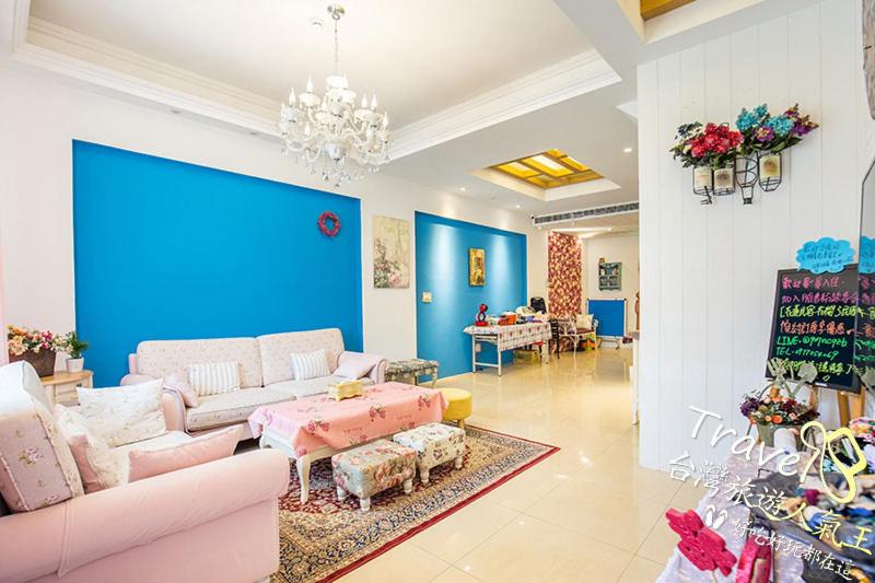 a living room with a pink couch and a blue wall at Flowers Blooming Homestay in Jian