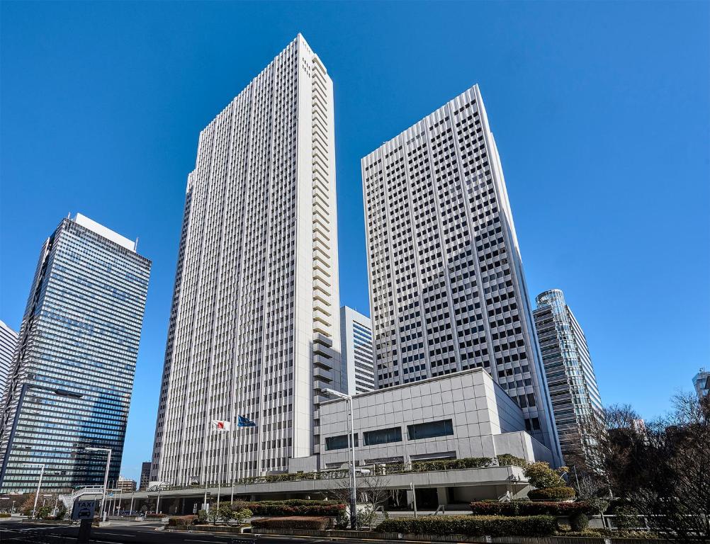 drie hoge gebouwen in een stad met een blauwe lucht bij Keio Plaza Hotel Tokyo in Tokyo