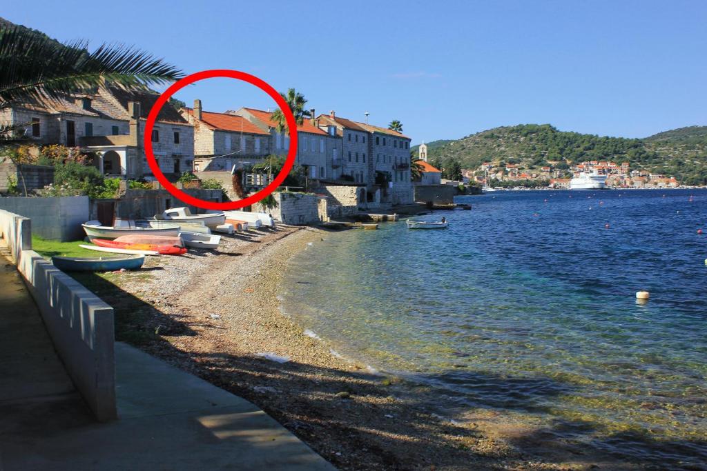 a red circle on a beach next to a body of water at Apartments by the sea Vis - 8885 in Vis