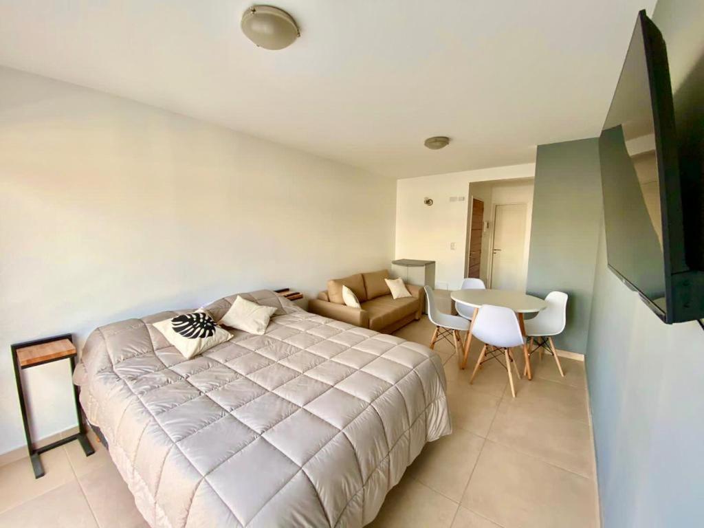 1 dormitorio con cama, mesa y sofá en Lofts Patagonia en San Carlos de Bariloche