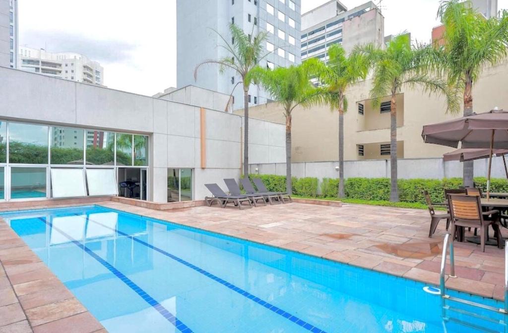 uma piscina com mesa e cadeiras ao lado de um edifício em Flat em Hotel na Bela Cintra próximo à Paulista e Consolação em São Paulo