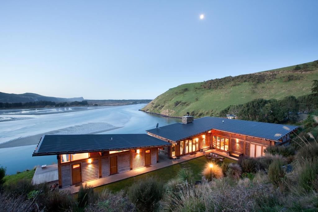 a house on the beach with a solar roof at Kaimata lodge in Dunedin