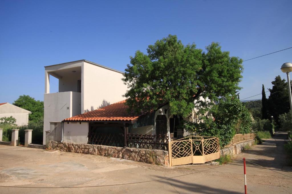 ein Gebäude mit einem Baum davor in der Unterkunft Apartments with a parking space Stari Grad, Hvar - 8752 in Stari Grad
