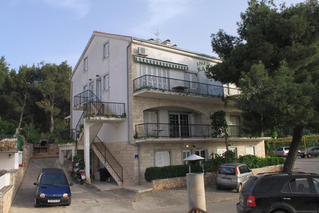 a white building with cars parked in front of it at Apartments with a parking space Jelsa, Hvar - 8732 in Jelsa