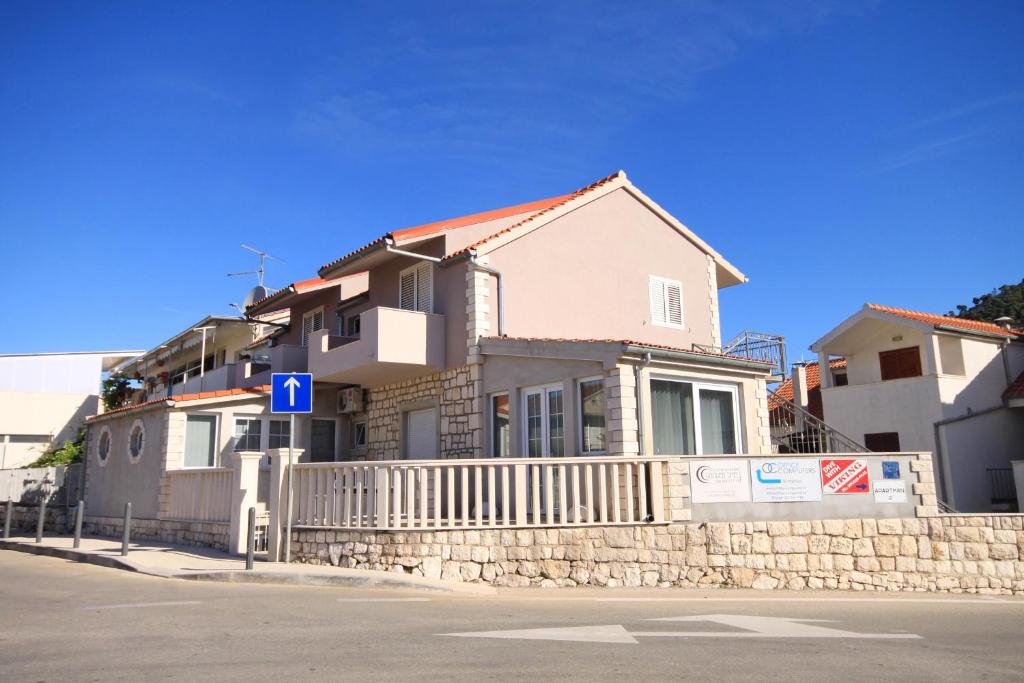 a house with a fence in front of a street at Apartments with a parking space Hvar - 8810 in Hvar