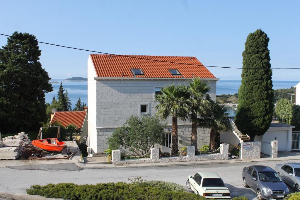 une maison avec un toit orange dans une rue dans l'établissement Apartments and rooms with parking space Mlini, Dubrovnik - 8994, à Mlini