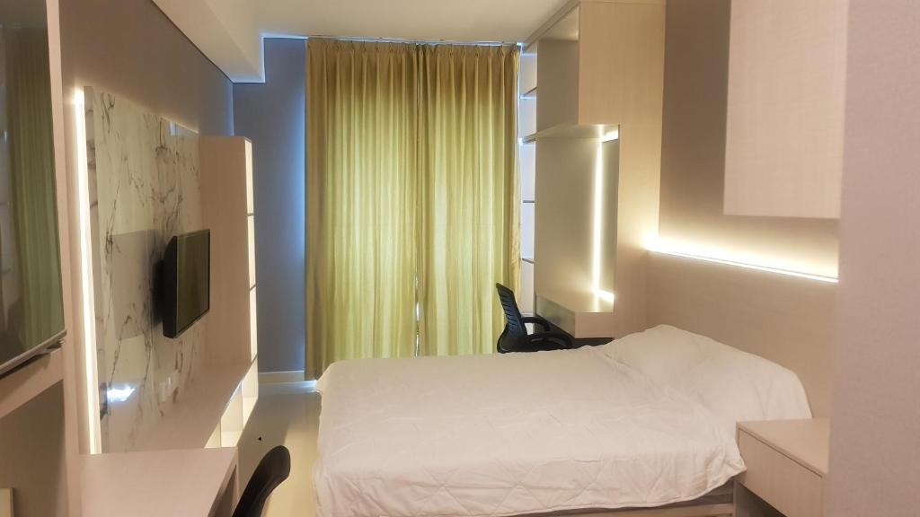 a bedroom with a white bed and a window at Apartemen Borneo Bay City (1 Bedroom Studio) in Klandasan Kecil