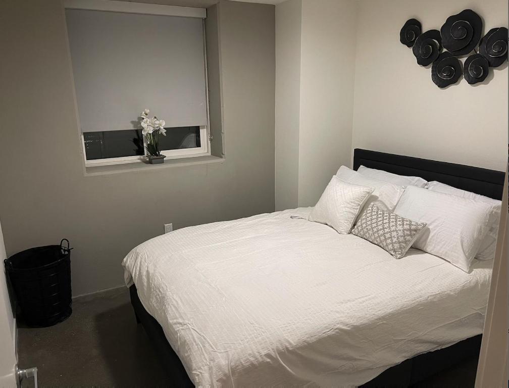 1 dormitorio con 1 cama con sábanas blancas y ventana en DTLA home away en Los Ángeles