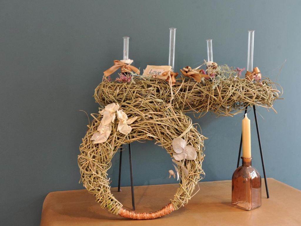 a sculpture of a bird nest on a table with a bottle at Splendid Holiday Home in Le Tignet South with Garden in Eisden