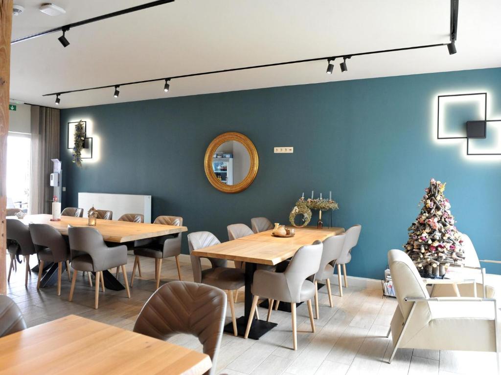 ein Esszimmer mit blauen Wänden, Holztischen und Stühlen in der Unterkunft Splendid Holiday Home in Le Tignet South with Garden in Eisden