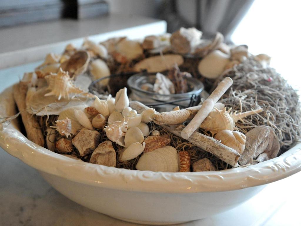 a white bowl filled with shells and sticks at Splendid Holiday Home in Le Tignet South with Garden in Eisden