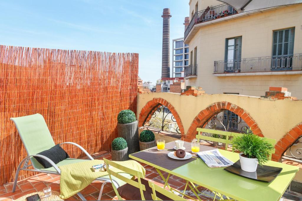 patio con mesa y sillas en el balcón en Feelathome Center Apartments, en Barcelona