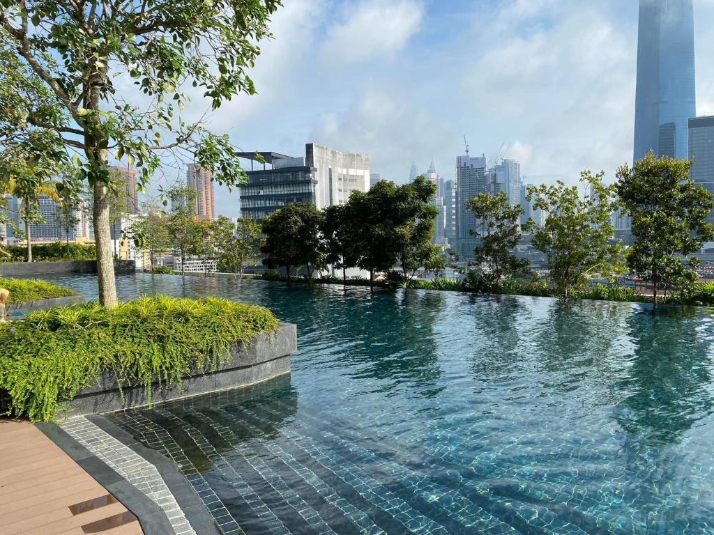 una gran piscina de agua con una ciudad al fondo en Infini Suites@ Continew Residence KL, en Kuala Lumpur