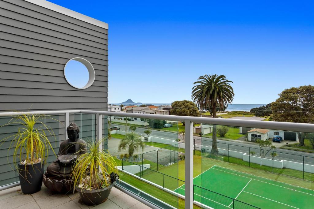a balcony with a view of a tennis court at Pohutukawa Paradise - Ōhope Holiday Apartment in Ohope Beach