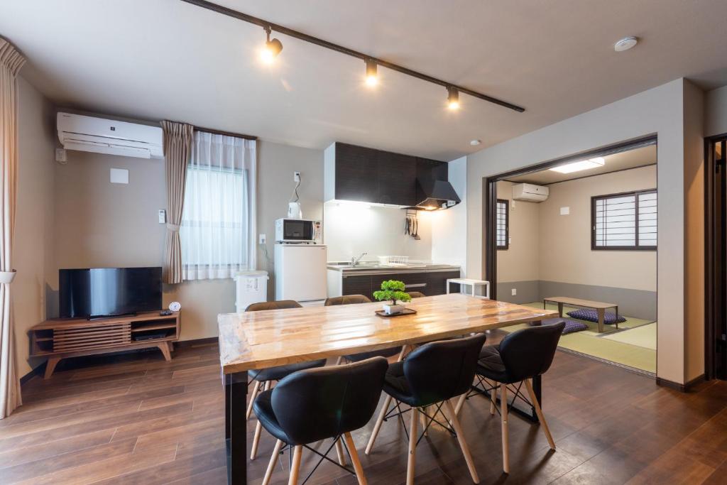a kitchen and dining room with a wooden table and chairs at FAMILIA糀谷 in Tokyo