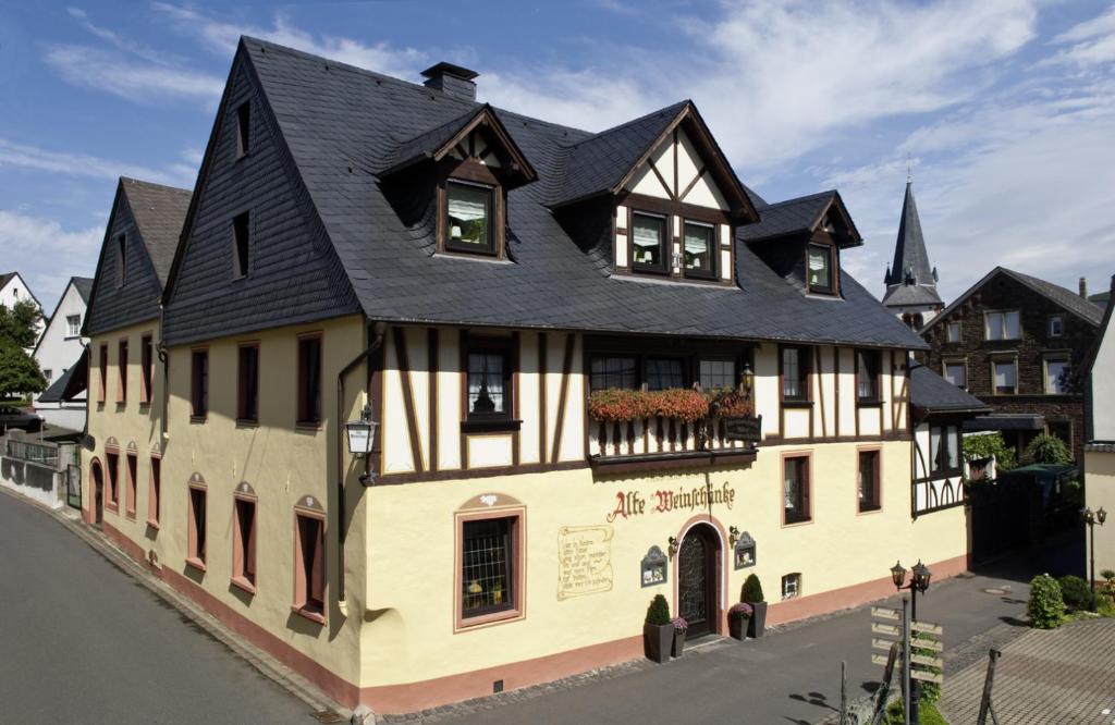 ein großes Haus mit schwarzem Dach in der Unterkunft Alte Weinschänke in Ellenz-Poltersdorf