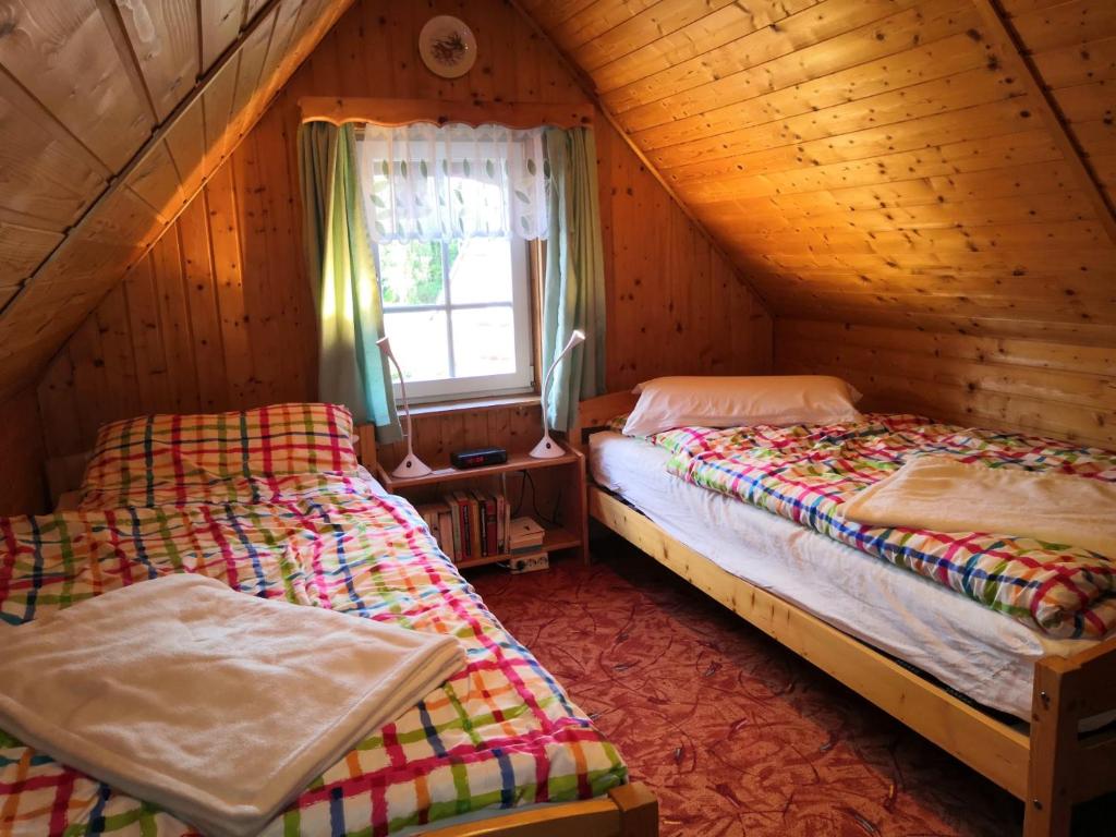 2 Betten in einem Holzzimmer mit Fenster in der Unterkunft Haus Fessel - Zeterklippe in Elend