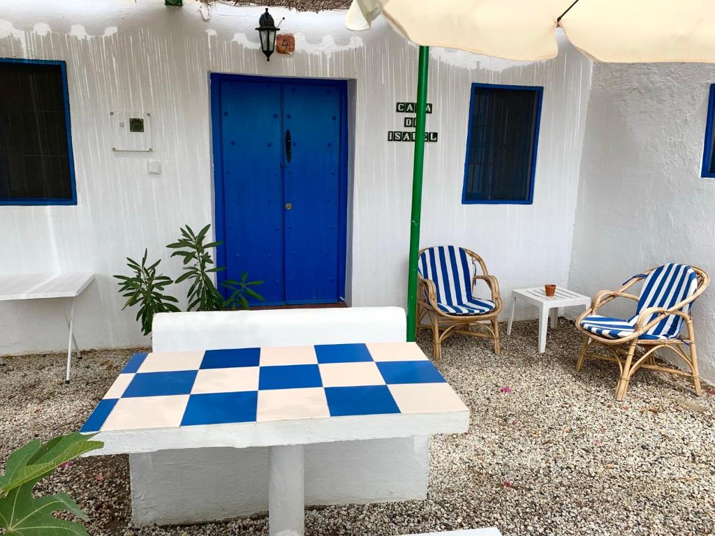 a patio with a table and chairs and an umbrella at Casa Isabel - La Almona Chica in El Chorro