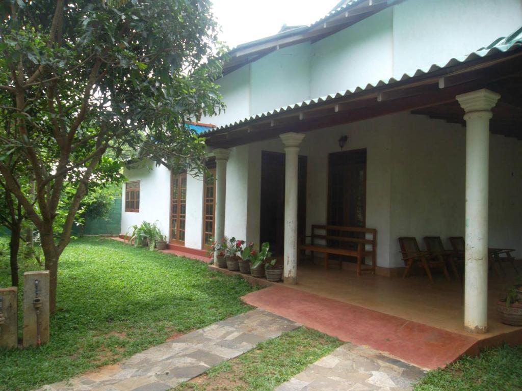 een huis met een veranda en stoelen in de tuin bij Green Villa Home in Anuradhapura