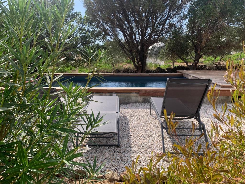 a television and a chair in a garden with a pool at Maison neuve avec piscine in Corbara
