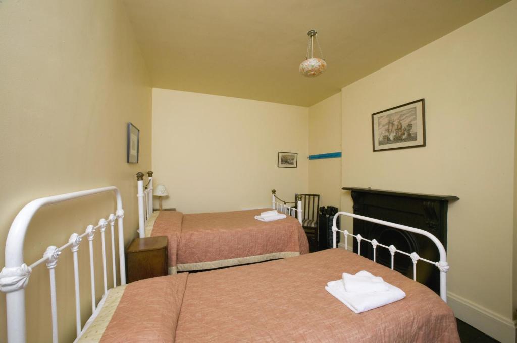 Pokój z 2 łóżkami i kominkiem w obiekcie Loop Head Lightkeeper's House w mieście Kilbaha