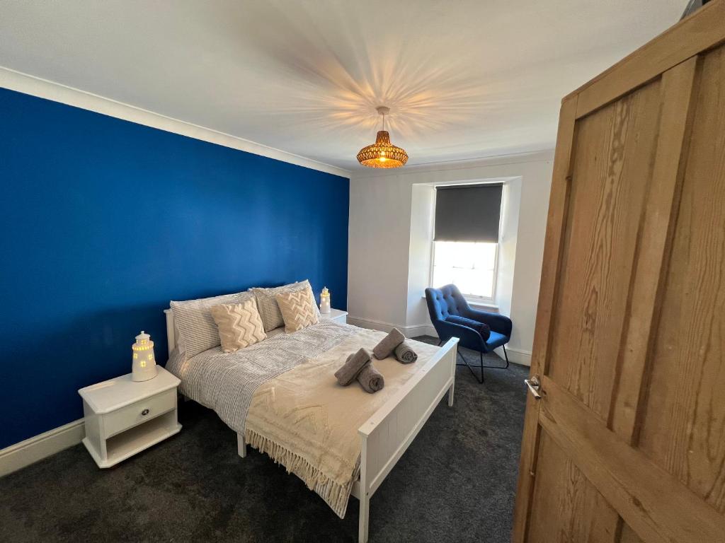 a blue bedroom with a bed and a blue wall at Casa Cozy in Torquay