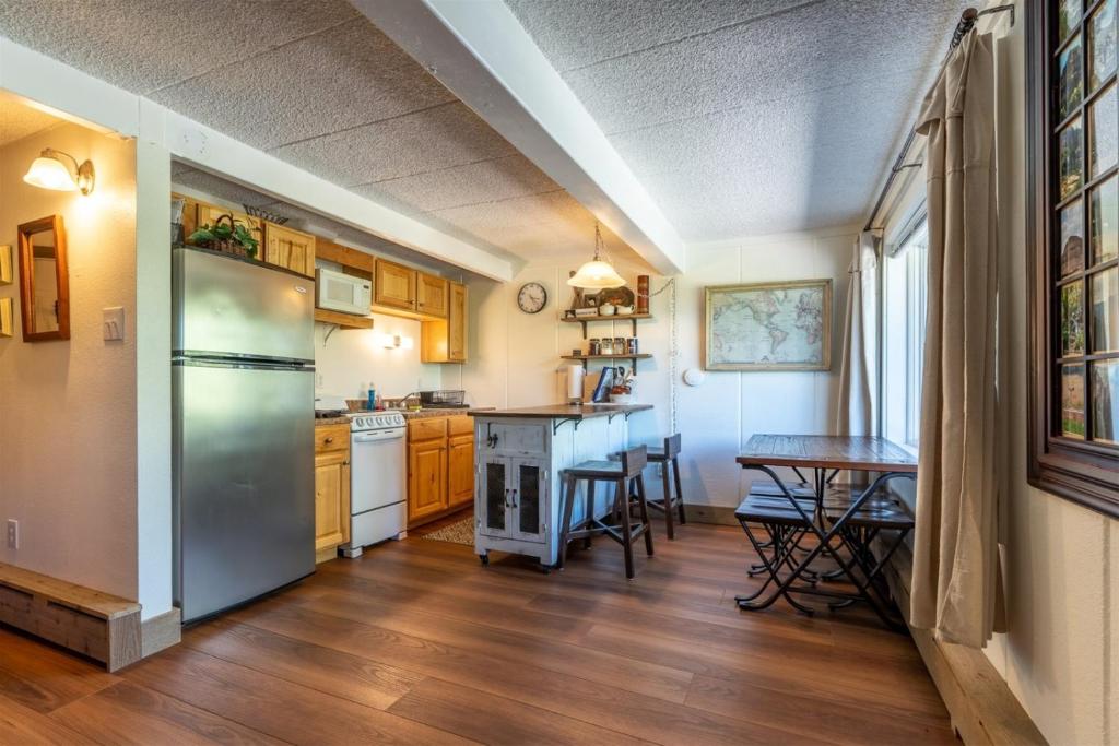 eine Küche mit einem Kühlschrank aus Edelstahl und einem Tisch in der Unterkunft Brettelberg Slopeside Condos F7 in Carbondale