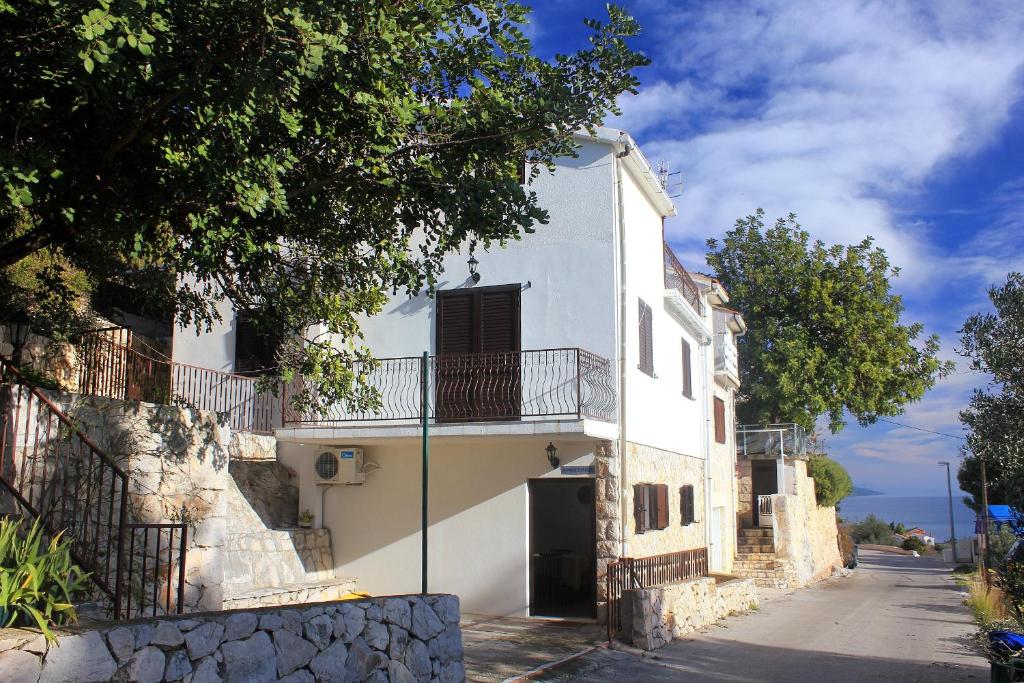 ein weißes Haus mit Balkon auf einer Straße in der Unterkunft Apartments with a parking space Zavala, Hvar - 8912 in Zavala
