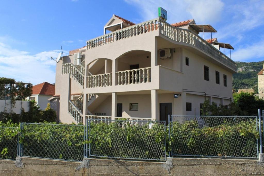 a white house with a fence in front of it at Apartments with WiFi Komiza, Vis - 8911 in Komiža