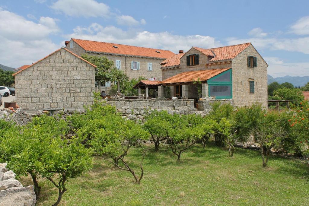 a large stone house with a yard with trees at Apartments with a parking space Mocici, Dubrovnik - 9081 in Mlini