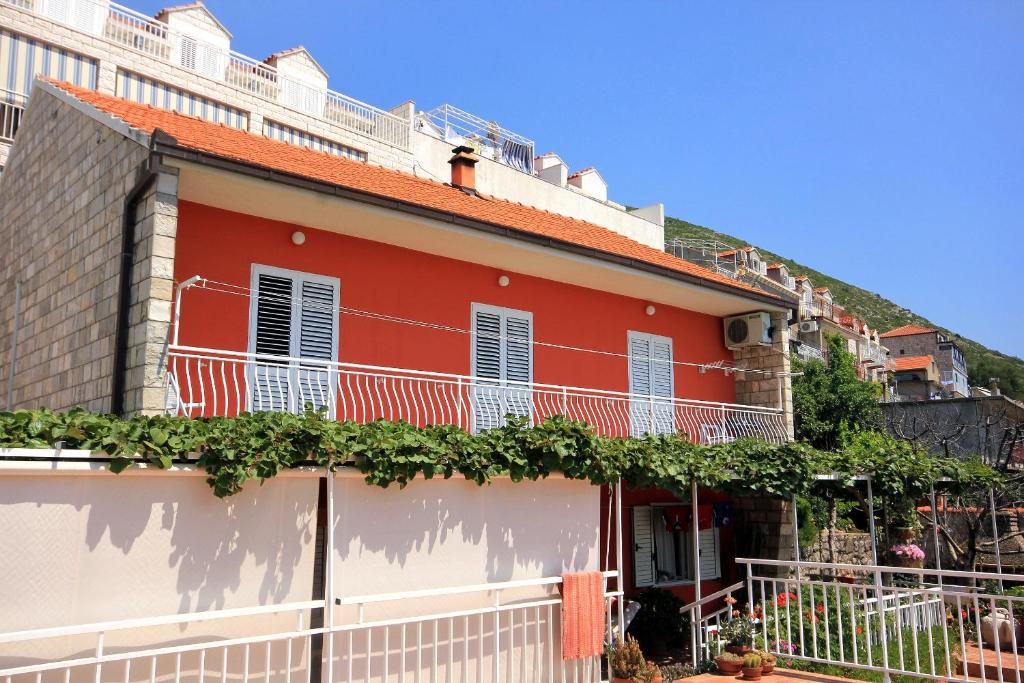 a red house with vines on the side of it at Apartments with WiFi Dubrovnik - 8975 in Dubrovnik