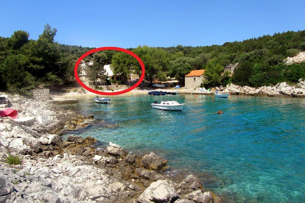 a red circle on a body of water with boats at Apartments by the sea Cove Milna - Zastrazisce, Hvar - 8951 in Zastražišće