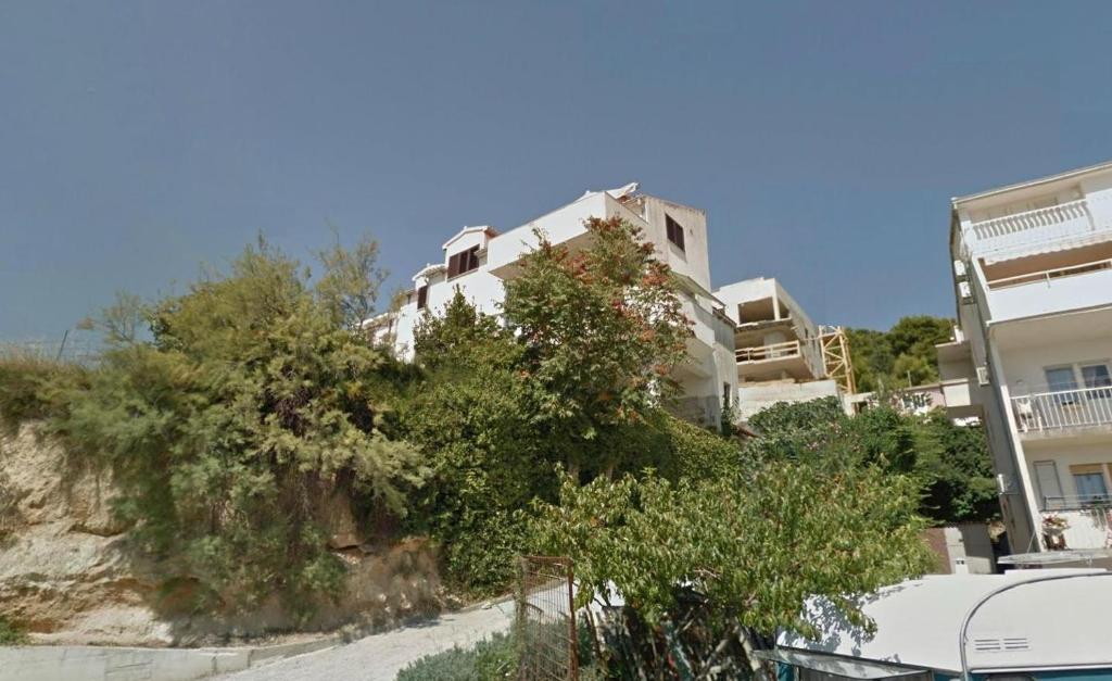un edificio bianco sul fianco di una collina di Apartments with a parking space Split - 8925 a Spalato (Split)