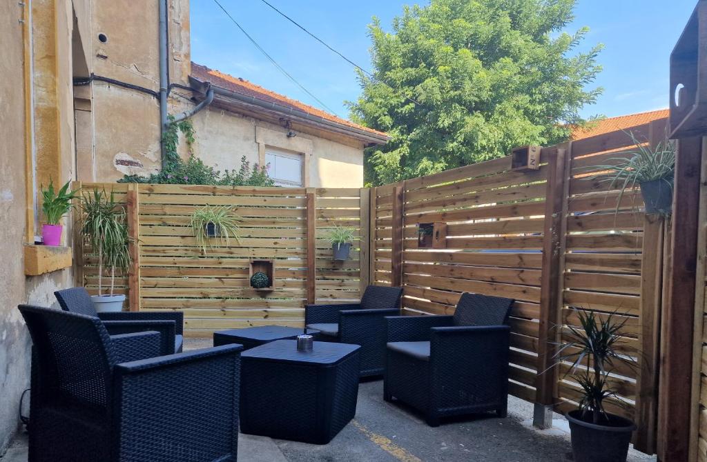 a patio with chairs and tables and a fence at appartement cosy en centre ville avec terrasse in Villefranche-sur-Saône