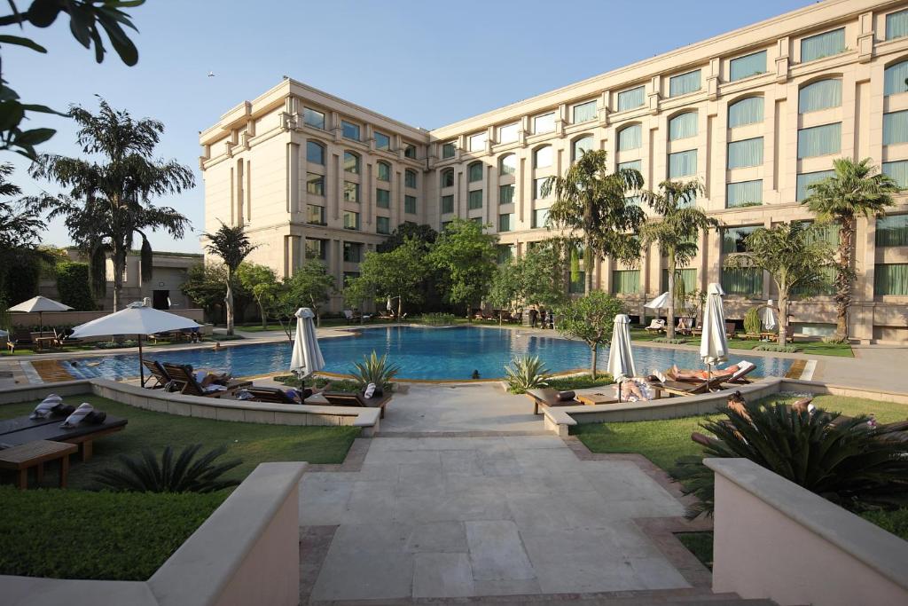un hotel con piscina di fronte a un edificio di The Grand New Delhi a Nuova Delhi