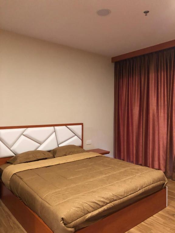 um quarto com uma cama e uma cortina vermelha em Skyline 10th floor Nagoya Central City Pelita Batam em Nagoya