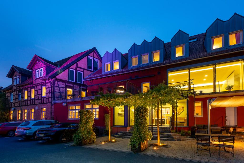 a row of buildings with cars parked in a parking lot at BEHLs Genusshotel im Brennhaus in Blankenbach