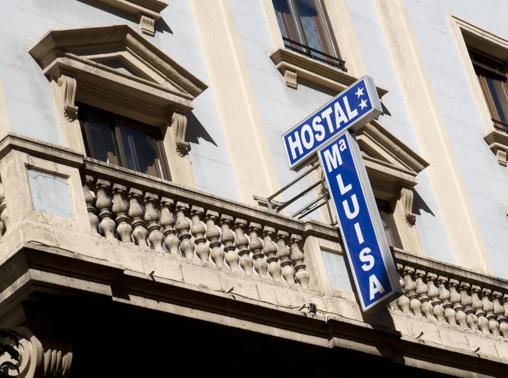 un letrero azul de la calle al lado de un edificio en Hostal María Luisa, en Madrid