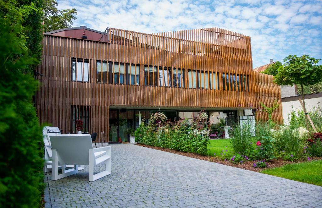 un gran edificio de madera con un jardín delante de él en Villa Lettonia en Jūrmala