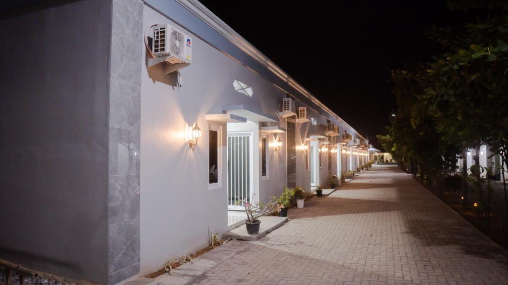 ein weißes Gebäude mit Lichtern in der Nacht in der Unterkunft Sitiinggil Guest House Syariah in Tegal