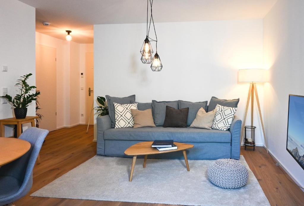 sala de estar con sofá azul y mesa en Apartment K13 en Bad Wiessee