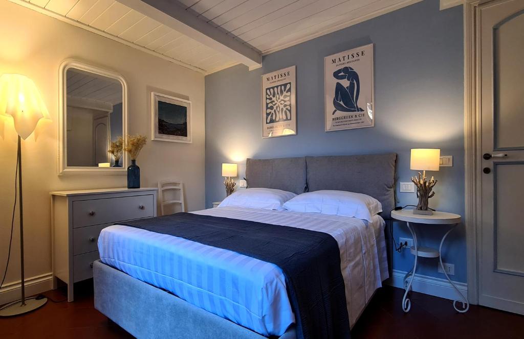 a bedroom with a large bed with a blue blanket at Suite Carducci Viareggio in Viareggio