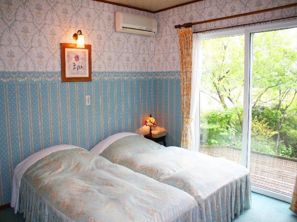 - une chambre avec un lit et une grande fenêtre dans l'établissement Gasthof yell / Vacation STAY 79362, à Kuroiso