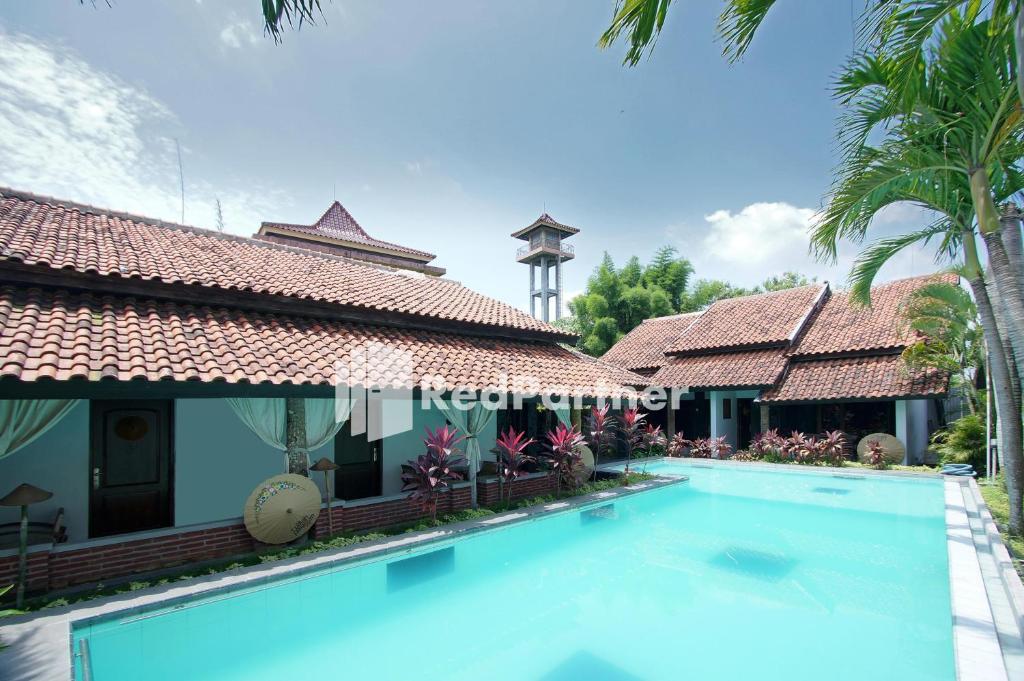 une villa avec une piscine dans un complexe dans l'établissement Rumah Palagan Yogyakarta RedPartner, à Ngaglik